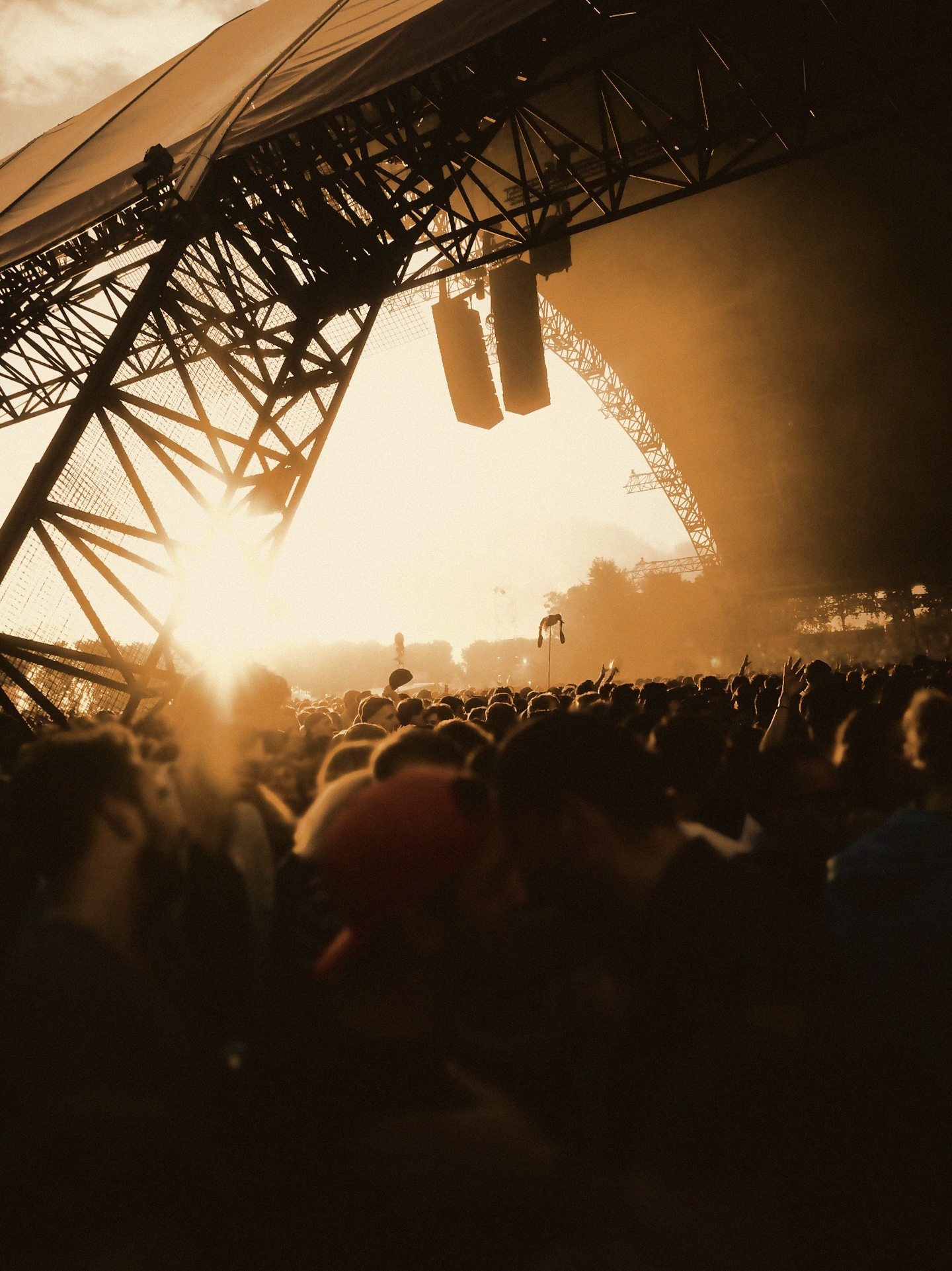 Festival stage rig against the sunset, crowd below